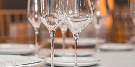 Empty wine glasses sit on a table in a restaurant