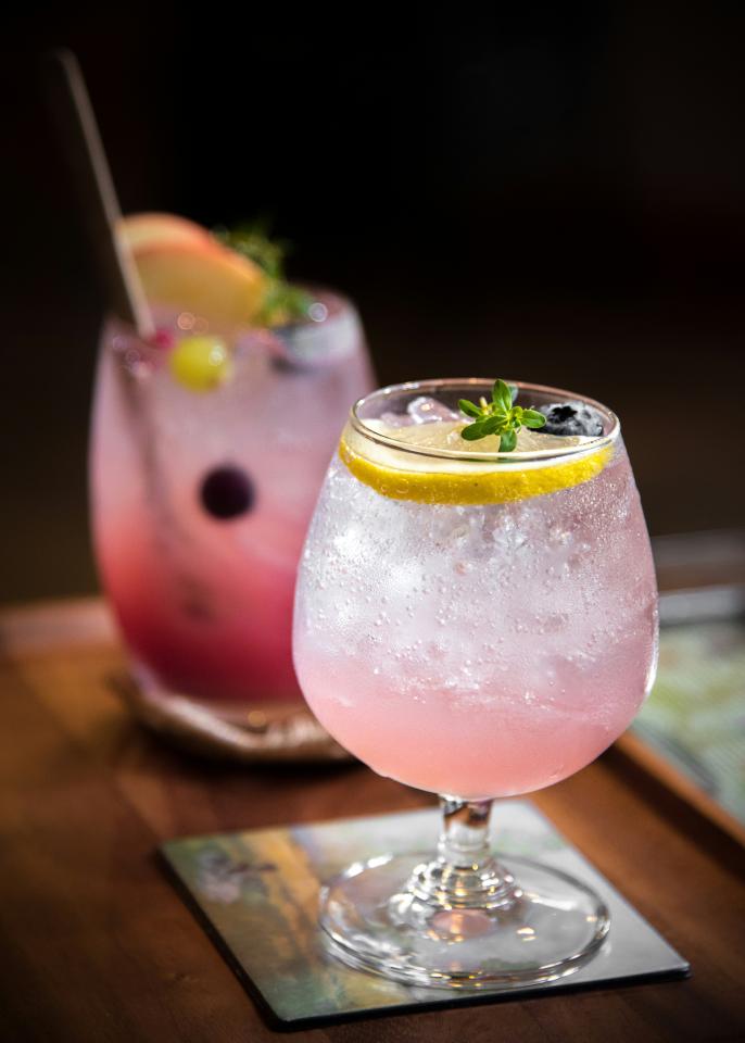 Alcoholic pink drinks with lemon wedges